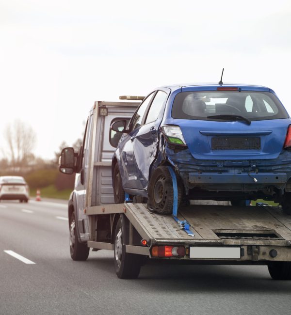 blue-car-trailer-is-being-towed-by-tow-truck
